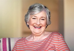 a woman smiling with her new dentures